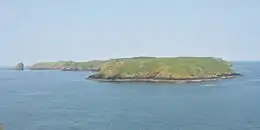 green-topped, treeless island in blue sea