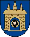 A coat of arms depicting a grey castle with three towers topped by crosses with a human head on the front door all on a blue background