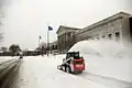 Skid loader clearing snow with snowblower attachment in Minneapolis, MN