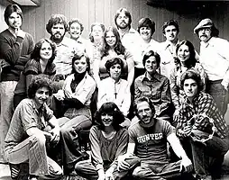 A black-and-white photograph of the band Sonseed, featuring 18 people standing and kneeling