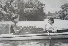 A black-and-white photograph of a man and a woman in a boat