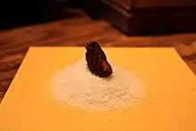 A blackened mummified toe on a pile of salt