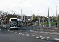 A city-bound tram has just left the stop and crossed the out-of-city track