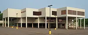 Southdale Library, a modern-style white building in an inverted step sequence supported by pillars over its parking lot on a sunny day