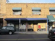 Photograph of the exterior of a two-story brick building from across the street