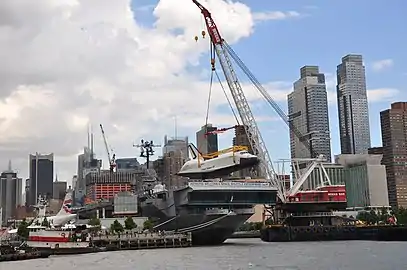 Weeks 533, a crane barge, lifts the Space Shuttle Enterprise