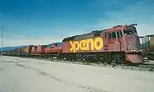 Rust-red locomotive with smooth front in rail yard