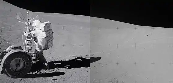 Spur crater in background, with astronaut David Scott at left next to rover.  The breccia boulder is at right in the distance.