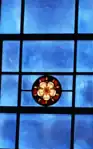 Of the 29 blue cathedral glass windows in the Church, each has its own liturgical stained glass symbol. This Rose represents the Virgin Mary.