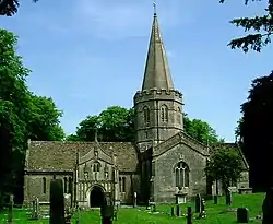 Stone building with arched doorway and windows. The hexagonal tower is topped by a short spire.