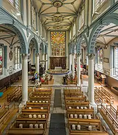 Interior of a church, looking towards the altar and stained glass windows