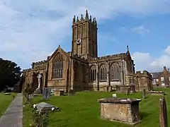 Elaborately ornamented stone building with square tower.