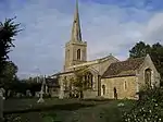 A stone church seen from the southeast, showing chancel, beyond which is a taller nave with a south aisle, and a tower with a spire