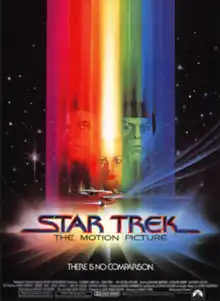 The faces of Kirk, Spock, and Ilia, covered by a spectrum of colored horizontal bars, on a starfield background.