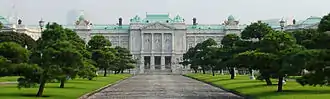 A large palace built of white stone in neo-baroque style. The façade is adorned with columns.