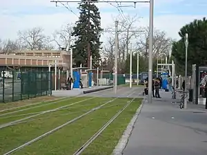 Double-track railway line in grass with shelters on side platforms