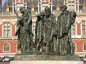 Six life-size bronze statues of men wearing robes and expressions of distress