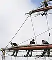 The length of chain running diagonally up and right from the bottom-left of this picture to the upper of the two yards is the fore-lower-topsail sheet. Some of the lines on Prince William's  larger sails are made of chain to handle the heavy loads while remaining flexible enough to pass through the various blocks on their route to the deck.