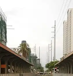 Poles 118 (foreground) and 119 (behind it) of the transmission line, with anchor designs, beside PNR and SLEx. Also seen is pole 120, having replaced an older structure to give way to the Skyway Stage 3 project.