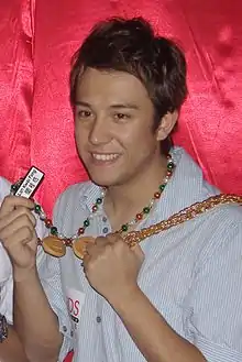 Cheung smiling and holding up party jewelry