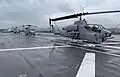 An AH-1W Super Cobra and S-70 Seahawk sit on the deck