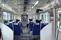 Interior of a 50090 series EMU on a TJ Liner service, showing forward-facing transverse seating configuration