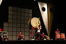 Members of Brazilian group Seiryu Daiko performing on stage with a variety of taiko.