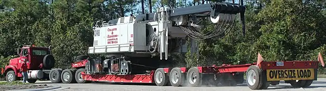 A lowboy trailer carrying a Link-Belt lattice crawler crane