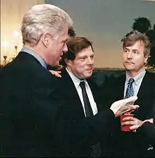 Three men in business attire engaged in discussion indoors