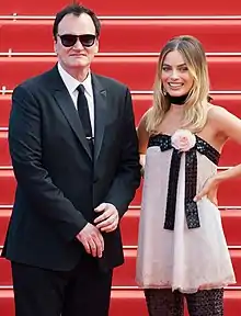 A picture of Quentin Tarantino and Australian actress Margot Robbie smiling towards the camera