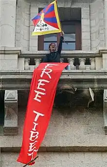 Tenzin, a human, waving a Free Tibet flag.