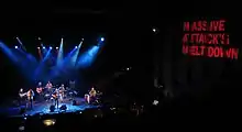 Callier and his band onstage as shot from above with a large Massive Attack banner on the side