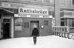 Snowy B&W image of the venue with a woman (Aimee Mann) standing in front