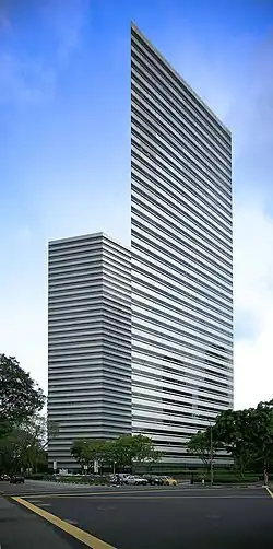 Ground-level view of a sharp, narrow corner on a building with a striped metal and glass facade