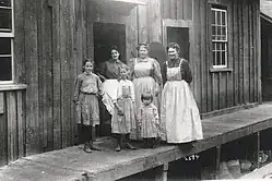 People standing in front of wooden building