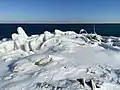 Rubble and other human-made artifacts covered by winter ice at the Leslie Spit.