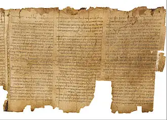 A long, tattered piece of old parchment with Hebrew writing.