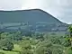 In the distance, A barren mountain ridge top viewed from the east. The ridge falls away to the north.