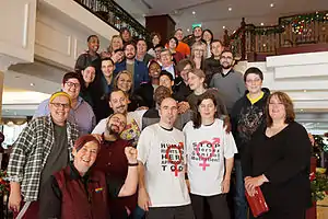 A group of people standing on a staircase in a hotel facing the camera.