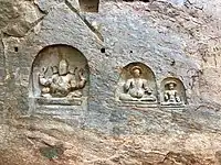 Bas-reliefs on the left side of cave temple entrance.