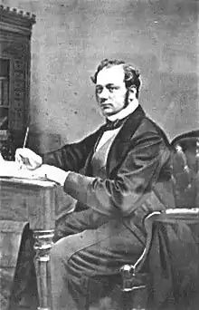 A monochrome picture of Thomas Evans Blackwell, an English engineer, sat at a writing desk