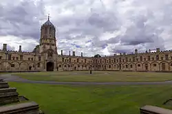 A wide view of a grass area surrounded by old buildings