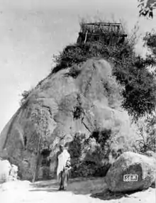 wooden tomb house built on top of large boulder