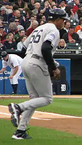 A man in baseball uniform jogs on toward the diamond on a baseball field.