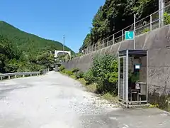 Access to the entrance on the south side of the bridge is via a gravel footpath. A public telephone call box has been installed. A toilet building can also be seen in the background.