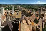 A small town dominated by many tall stone towers..