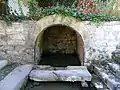 Fountain in Tourtoirac (Dordogne), probably dating to Roman times or earlier.  The inhabitants have built a wall around a spring.