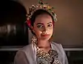 A girl wearing bodo blouse with jewelries; headbands, earrings and necklace