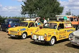 Two yellow cars with their drivers shaking hands