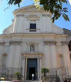 Front of an old white church, with a man entering